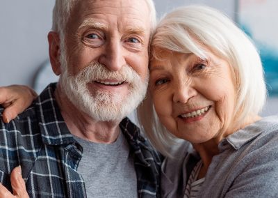 an elderly couple both smiling